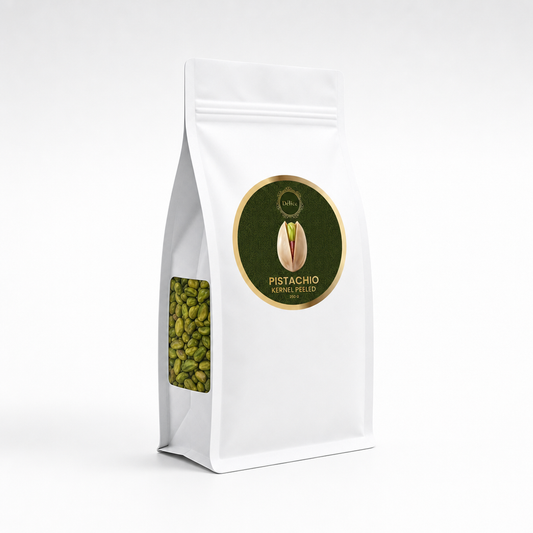 A white stand-up pouch of Pistachio peeled kernels, featuring a circular green and gold label on the front and a clear window showing the green pistachio beans inside, set against a plain white background.
