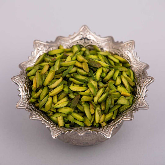 Fresh and premium green slivered pistachios on a silver bowl.