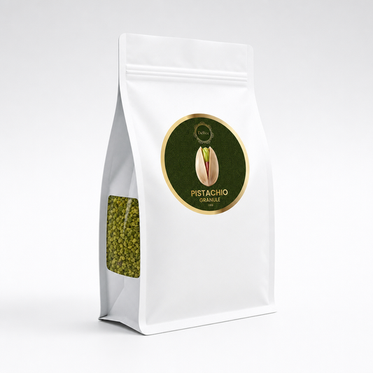 A white stand-up pouch of pistachio kernels with a clear window showing green pistachios inside. The front features a circular dark green and gold label with a pistachio illustration and the text 'PISTACHIO KERNELS, PULLED'.